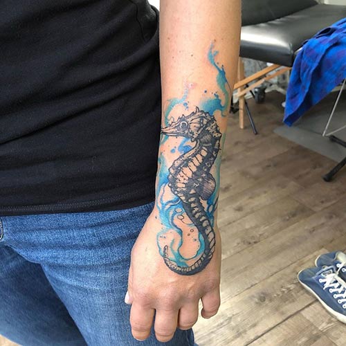 Seahorse colored hand tattoo design