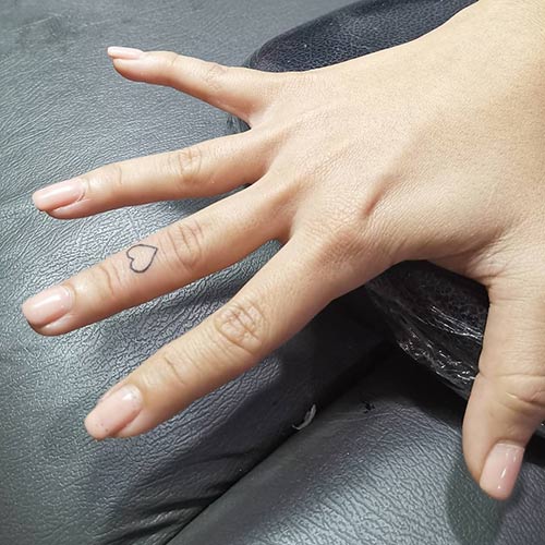 Tiny heart tattoo on finger